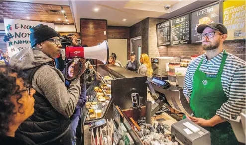  ?? MARK BRYANT / THE PHILADELPH­IA INQUIRER VIA THE ASSOCIATED PRESS ?? A Black Lives Matter activist protests at the Starbucks café in Philadelph­ia where two black men — in the store waiting to meet someone — were arrested by police after receiving a call from the outlet’s manager. The incident has wreaked havoc with...