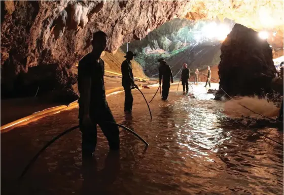  ?? FOTO: TT/AP ?? Thailändsk­a soldater försöker leda bort vatten från grottan.