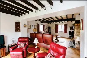  ??  ?? COUNTRY STYLE: The sitting room with stone fireplace and exposed beams