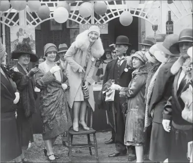  ?? London Express / Getty Images ?? A woman pulling the cork on a bottle in 1928 at a garden party.
