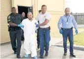  ?? KIMBERLY C. MOORE/AP ?? Quadruple murder suspect Bryan Riley is led from the Polk County Sheriff’s Office in Lakeland on Sunday by Deputy Steve Neil, left, Capt. Bart Davis and Detective Brett Bulman.