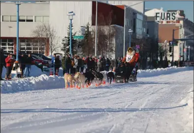  ?? Photo by Megan Gannon ?? DEFENDING CHAMPION— Brent Sass and his team mush down 4th Avenue during the ceremonial start. Sass, of Eureka, aims to repeat his 2022 victory.