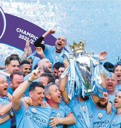  ?? MARTIN RICKETT/AP ?? Manager Pep Guardiola, top, celebrates Manchester City’s latest Premier League title with players and staff Sunday.