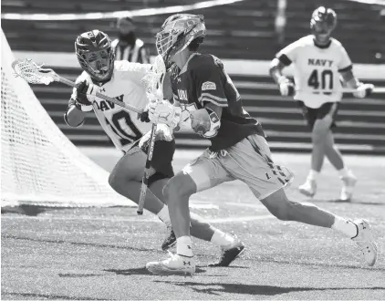  ?? PAUL W. GILLESPIE/CAPITAL GAZETTE ?? Loyola’s Adam Poitras moves the ball as Navy’s Colin Meehan defends in the second quarter. The visiting Loyola Greyhounds defeated the Navy Midshipmen in men’s NCAA lacrosse at Navy-Marine Corps Memorial Stadium in Annapolis on Saturday,