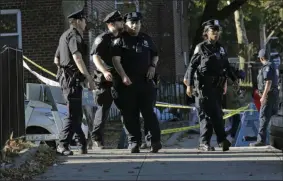  ?? SETH WENIG- THE ASSOCIATED PRESS ?? Emergency personnel walk near the scene of a fatal shooting of a New York City police officer in the Bronx borough of New York, Sunday, Sept. 29, 2019.