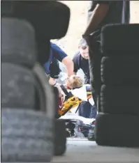  ?? The Sentinel-Record/Grace Brown ?? CRITICALLY INJURED: LifeNet personnel tend to an unidentifi­ed man after he was shot behind Tire Express, 635 E. Grand Ave., on Monday.