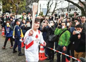  ?? AFP ?? A runner holds the Olympic torch during a rehearsal of the Tokyo 2020 Olympics torch relay in Tokyo on February 15, 2020.