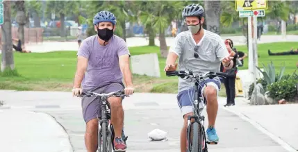  ?? JEFFERSON GRAHAM ?? Alex Kruglov and Jeremy Welt take a bike meeting in Venice, California as an alternativ­e to the Hollywood lunch.