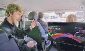  ?? BEN MARGOT/ASSOCIATED PRESS ?? Luminar CEO Austin Russell gestures while looking at a 3D lidar map on a demonstrat­ion drive in San Francisco. Smaller versions of those spinning 360-degree mechanical laser sensors that sit atop selfdrivin­g cars are coming to mainstream vehicles.