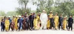  ?? — AFP ?? BANNU, Pakistan: Pakistani father Gulzar Khan (center) 57, who has 36 children from his three wives, walks with his children as they return home after school in the northweste­rn town of Bannu.