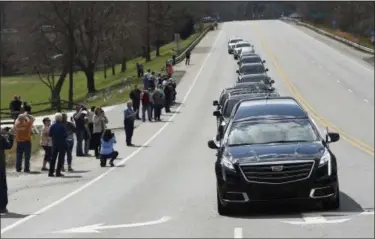  ?? KATHY KMONICEK — THE ASSOCIATED PRESS ?? People line the street as the hearse carrying the body of Rev. Billy Graham leaves the Billy Graham Training Center at the Cove on Saturday in Asheville, N.C.