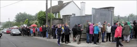  ??  ?? The queue for Leinster Championsh­ip semi-final tickets stretches out of Wexford Park and around the corner into Corish Park on Wednesday morning. RIGHT: A garda attempts to guide traffic around parked cars outside Wexford Park.