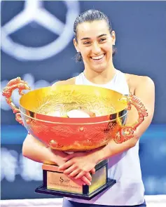  ??  ?? Caroline Garcia of France holds the trophy after winning the women’s singles final against Simona Halep of Romania at the China Open tennis tournament in Beijing on October 8, 2017. - AFP photo