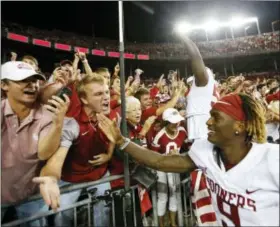  ?? PAUL VERNON — THE ASSOCIATED PRESS ?? Oklahoma players celebrate with fans after beating Ohio State Saturday in Columbus, Ohio.