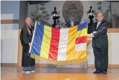  ??  ?? A cloth banner is unveiled to show many coloured patches symbolisin­g the unity of the Buddhist order.