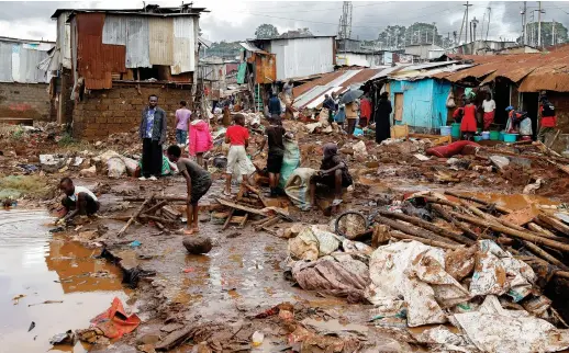  ?? Reuters ?? Residents sift through the rubble on Thursday as they recover their belongings after the Nairobi River burst its banks and destroyed their homes within the Mathare Valley settlement in Kenya.