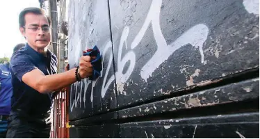  ??  ?? MAYOR ISKO CLEANS GRAFFITI – Manila Mayor Isko Moreno shows to reporters and photograph­ers how hard it is to remove graffiti on a wall near City Hall on Monday. Moreno fumed on a leftist organizati­on’s move to deface the City Hall underpass last week. (Jansen Romero)