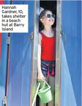  ??  ?? Hannah Gardner, 10, takes shelter in a beach hut at Barry Island