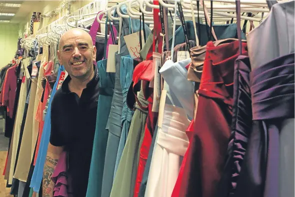  ??  ?? Paul with some of the bridesmaid dresses donated to the hospice shop at the Wellgate Centre.