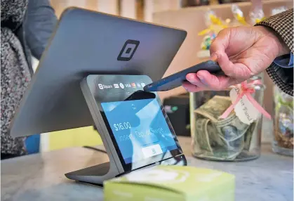  ?? DAVID PAUL MORRIS/BOOMBERG NEWS ?? A customer uses a smartphone to make a payment on a Square device in San Francisco.