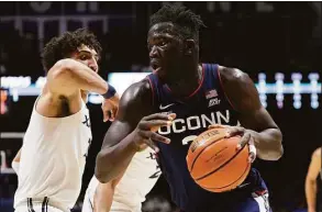  ?? Dylan Buell / Getty Images ?? UConn’s Adama Sanogo dribbles the ball while being guarded by Xavier’s Colby Jones at the Cintas Center on Saturday in Cincinnati, Ohio.