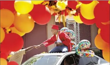  ?? Genaro Molina Los Angeles Times ?? JORDAN REED, 18, celebrates at a drive- by graduation ceremony in June at Fairfax High School in Los Angeles. The COVID- 19 pandemic has cut into the number of high school graduates who enroll in college.