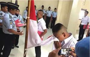  ?? MAYA APRILIANI/JAWA POS ?? SEREMONI: Petugas baru Lapas Kelas II-A Sidoarjo diminta mencium bendera Merah Putih sebelum menerima SK.