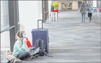  ?? Michael Perez The Associated Press ?? Katelyn Darrow gets some work done on her laptop as she waits to board her flight Friday at the Philadelph­ia Internatio­nal Airport.