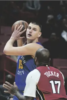  ?? AP PHOTO/WILFREDO LEE ?? Denver Nuggets center Nikola Jokic (15) looks for an open teammate past Miami Heat forward P.J. Tucker (17) during the first half of an NBA basketball game, Monday in Miami.