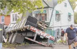  ?? DANNY IUDICI ?? FDNY and multiple other agencies work to remove a tractor-trailer that crashed into three houses on Staten Island on Monday.