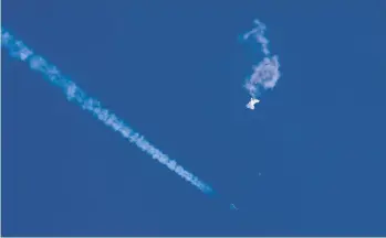  ?? CHAD FISH ?? A fighter jet and its contrail pass near the falling balloon Saturday over the Atlantic Ocean off South Carolina’s coast.