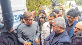  ?? FOTO: ATEC ?? Phlilipp Enderle zeigt dem iranischen Energiemin­ister Reza Ardakanian Flaschen mit Wasser vor und nach der Aufbereitu­ng.