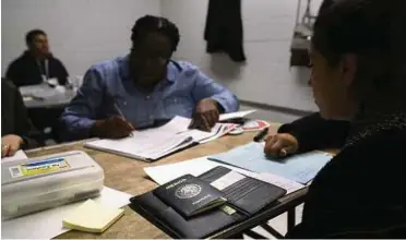  ??  ?? A volunteer helping a Mexican immigrant (right) to complete her United States citizenshi­p applicatio­n in New York on Saturday.