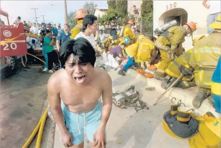  ?? J. Albert Diaz Los Angeles Times ?? A YOUNG MAN weeps after seeing a dead child in front of an apartment complex that burned on South Burlington Avenue in May 1993.