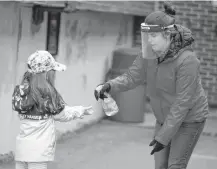  ?? REUTERS • FILE ?? A student has her hands sanitized in the schoolyard. A proposed hybrid model which calls for children to go to school one day of the week and do online work the rest of the week has families frustrated.