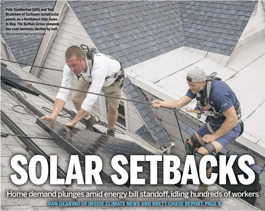  ?? ASHLEE REZIN GARCIA/SUN-TIMES ?? Pete Southerton (left) and Tom Bradshaw of Certasun install solar panels on a Northwest Side home in May. The Buffalo Grove company has seen business decline by half.