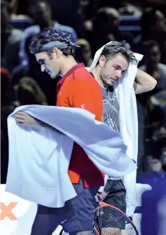  ??  ?? Switzerlan­d’s Rodger Federer (L) and Switzerlan­d’s StanislasW­awrinka (R) exchange sides between games during their semi-final singles match on day seven of the ATP World Tour Finals tennis tournament in London on November 15, 2014. - AFP photo