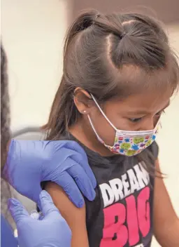  ?? MEGAN MENDOZA/THE REPUBLIC ?? Emma Jaime, 6, gets her COVID-19 vaccine at John F. Long Elementary School in Phoenix on Friday.