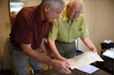  ?? Jessica Hill/Associated Press photos ?? Dave Ware, left, and his father, Fred Ware, look over a deed and copy of a covenant for their home July 17 in Manchester, Conn. The pair recently found a whites-only covenant on the property dating back to 1942, the text of which is seen below, when researchin­g the title chain.