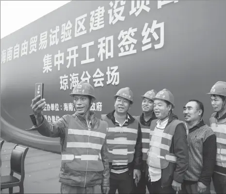  ?? YUAN CHEN / PROVIDED TO CHINA DAILY ?? Employees take pictures during the commenceme­nt ceremony of the Pilot Free Trade Zone project in Qionghai, Hainan province.