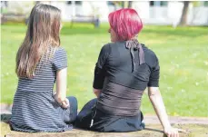  ?? FOTO: DPA ?? Mutter Sonja sitzt mit ihrer Tochter Lea auf einer Parkbank am Diakoniekl­inikum. Sonja hat eine Borderline-Störung.