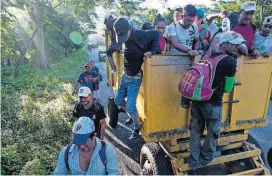  ?? [AP PHOTO] ?? Central American migrants traveling with a caravan to the U.S. make their way Thursday to Pijijiapan, Mexico. The sprawling caravan of migrants hoping to make their way to the United States set off again, forming a column more than a mile long as the group trekked out of the town of Mapastepec in southern Mexico before dawn.