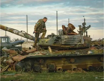  ?? EFREM LUKATSKY/AP ?? A Ukrainian soldier inspects a damaged Russian tank in the retaken village of Chornobaiv­ka near Kherson, Ukraine, on Tuesday.