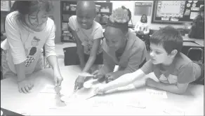  ??  ?? Spelling: Yocum Elementary second graders Sandra Sebastian, Sovereign Allen, Macedes Curry and Caleb Digby play Spelling SWAT in Stacy Gulick’s class.