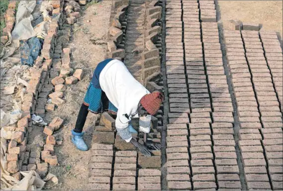  ?? Photo: Per-anders Pettersson/getty Images ?? Self-employed: Ntombelang­a Mathshata, 49, lays out bricks to dry in Mthatha, Eastern Cape. She lives with her mother Ndenzeni Njwenene, 82, who started the small business in 1967 to support her family.