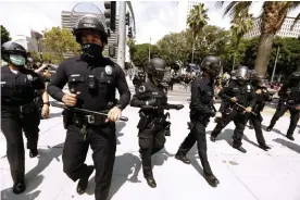  ?? Genaro Molina/Los Angeles Times/Rex/Shuttersto­ck ?? Los Angeles police officers survey a protest in downtown Los Angeles on 14 August. Photograph: