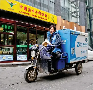  ??  ?? A deliveryma­n rides a vehicle with the logo of ZTO Express in Beijing on Thursday. REUTERS