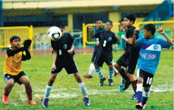  ?? (SUN.STAR FOTO/ALEX BADAYOS) ?? ONE-SIDED. A defender from St. Thomas School of Danao heads off an attempt by Don Bosco Technologi­cal Center in the Milo Little Olympics elemntary football finals. DBC won, 4-0, to keep the title.