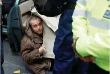  ??  ?? TRAFFIC JAM: A protester attaches himself to a car