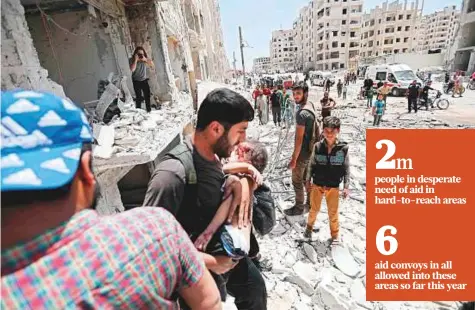  ?? AFP ?? A man carries a wounded child out of a building following a car bomb explosion in the northern Syrian city of Idlib.